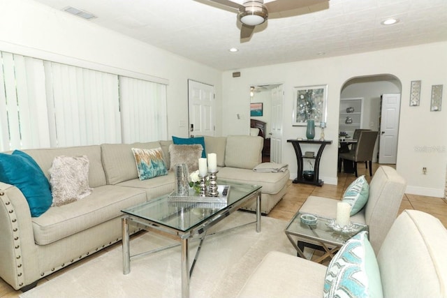 tiled living room featuring ceiling fan and built in shelves