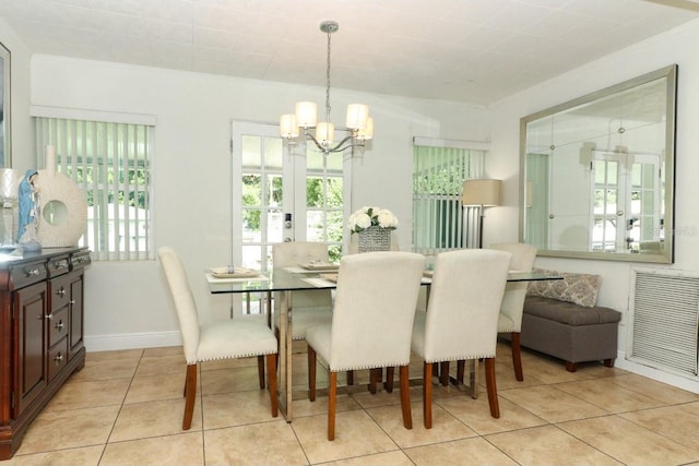 tiled dining room with french doors and a chandelier