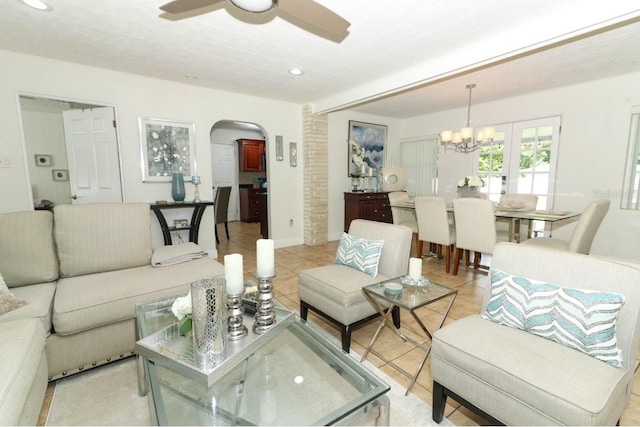 tiled living room with brick wall and ceiling fan with notable chandelier