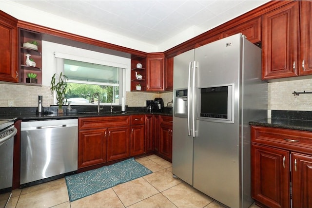 kitchen featuring backsplash, sink, dark stone countertops, appliances with stainless steel finishes, and light tile patterned floors