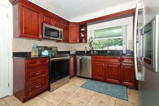 kitchen featuring sink, stainless steel appliances, decorative backsplash, and light tile patterned floors