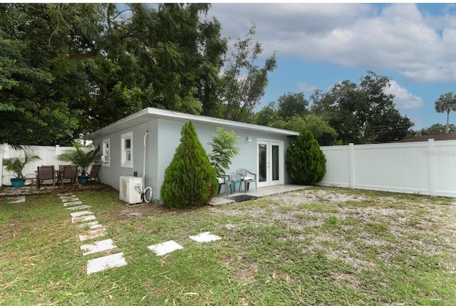 back of house with french doors and a yard