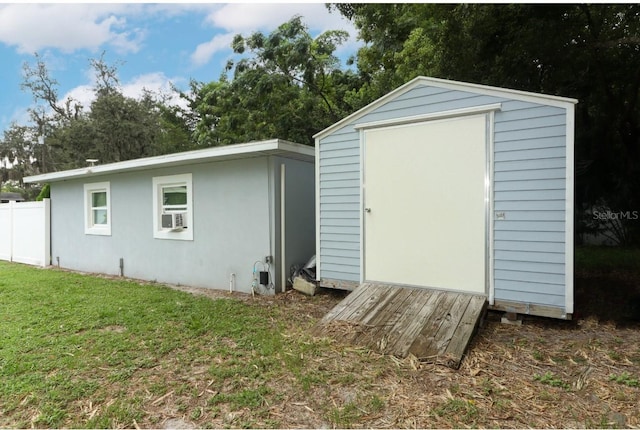 view of outbuilding featuring cooling unit and a yard