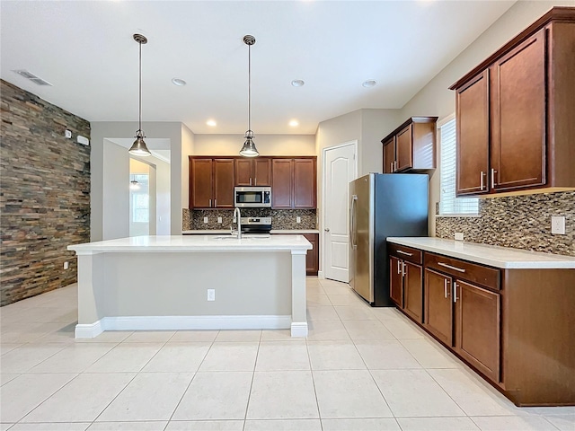 kitchen with appliances with stainless steel finishes, decorative light fixtures, light tile patterned flooring, and backsplash