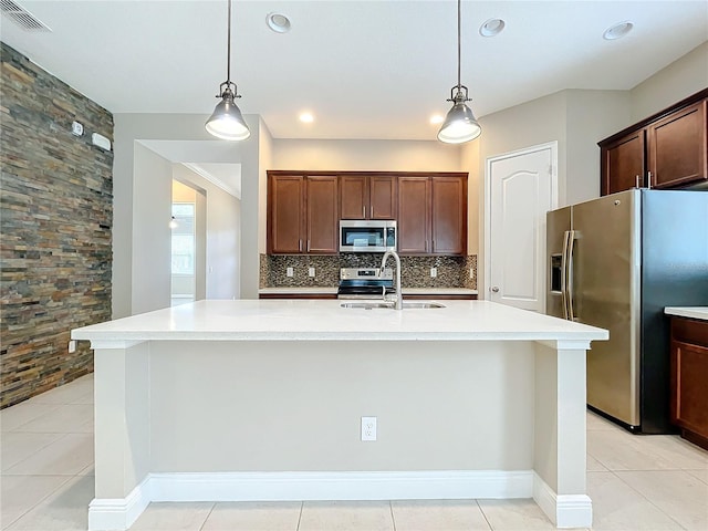 kitchen with appliances with stainless steel finishes, light tile patterned floors, sink, and tasteful backsplash