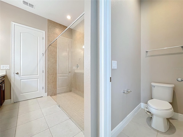 bathroom featuring tile patterned floors, vanity, tiled shower, and toilet