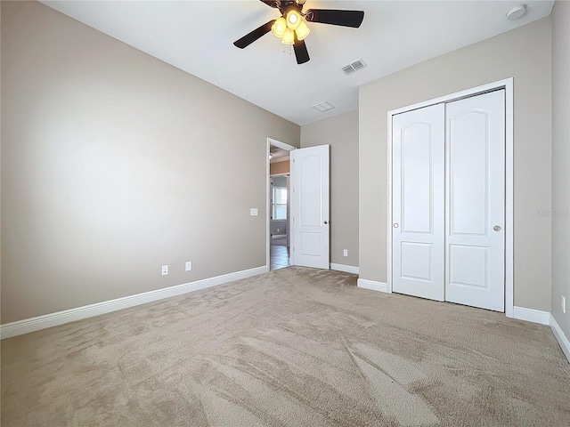 unfurnished bedroom featuring ceiling fan, light carpet, and a closet