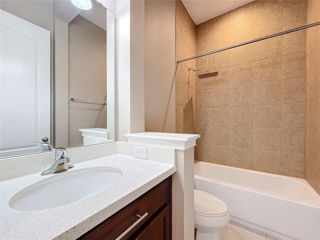 full bathroom featuring tile patterned flooring, toilet, tiled shower / bath combo, and vanity