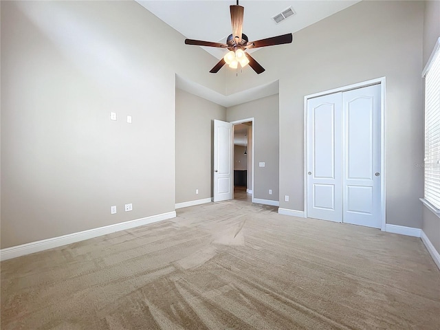 unfurnished bedroom featuring a closet, ceiling fan, and light carpet