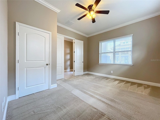 unfurnished bedroom with ceiling fan, crown molding, light colored carpet, and a closet