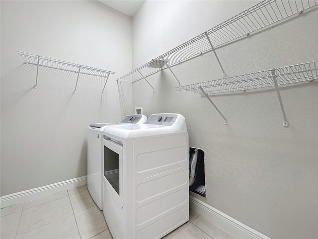 clothes washing area with light tile patterned floors and washing machine and dryer