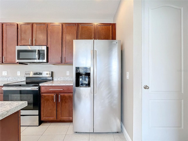 kitchen featuring light tile patterned floors and stainless steel appliances