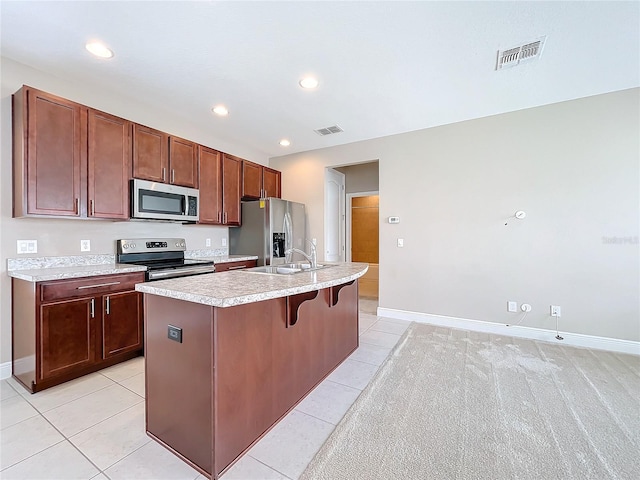 kitchen featuring light colored carpet, sink, a kitchen island with sink, and stainless steel appliances