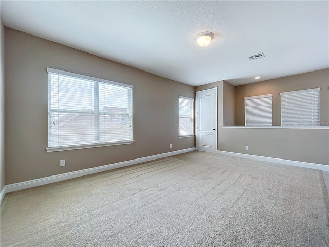 unfurnished room featuring light carpet