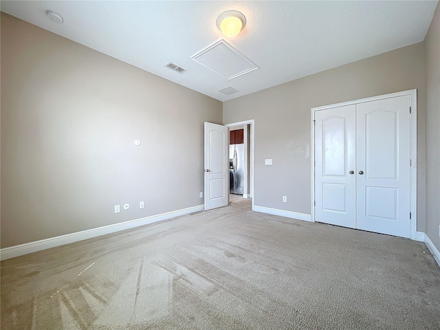 unfurnished bedroom with stainless steel fridge, a closet, and light carpet