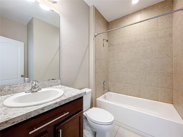 full bathroom featuring tiled shower / bath combo, tile patterned flooring, toilet, and vanity