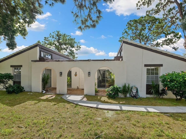 mediterranean / spanish-style home featuring a front yard