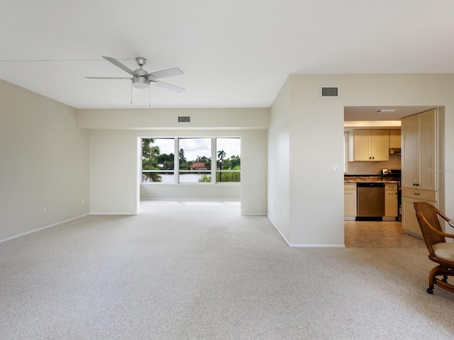 spare room with ceiling fan and light carpet