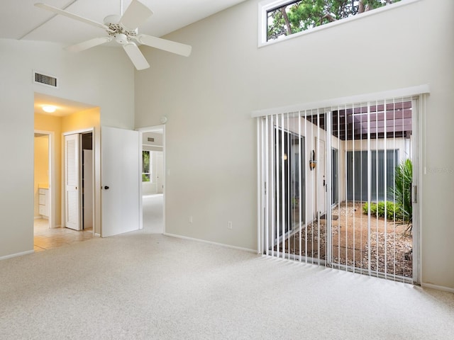 unfurnished room featuring light carpet, high vaulted ceiling, and ceiling fan