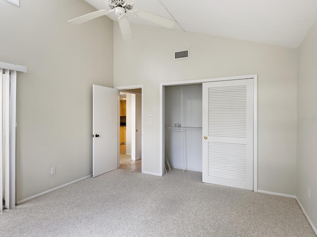 unfurnished bedroom featuring high vaulted ceiling, a closet, ceiling fan, and light carpet