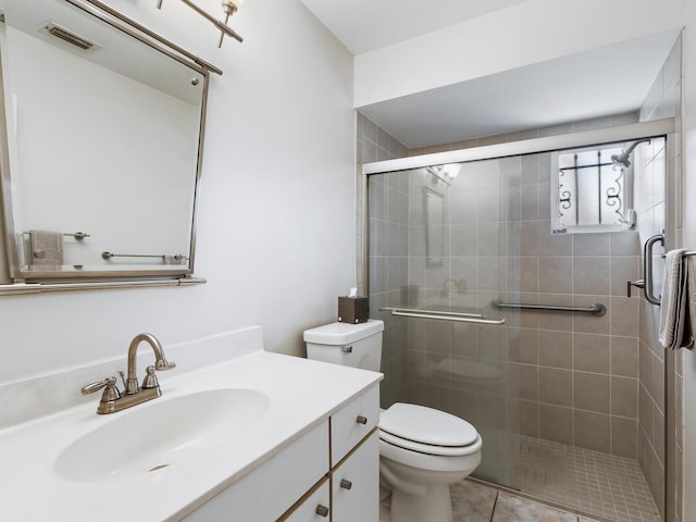 bathroom with vanity, toilet, tile patterned floors, and a shower with door