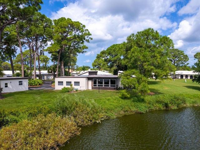 rear view of house with a yard and a water view