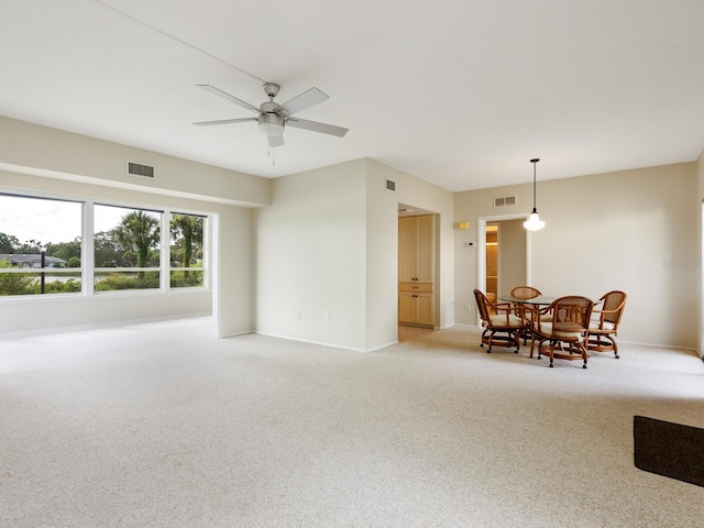 interior space with light carpet and ceiling fan