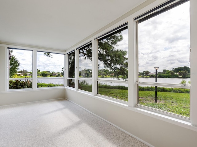 unfurnished sunroom featuring a water view