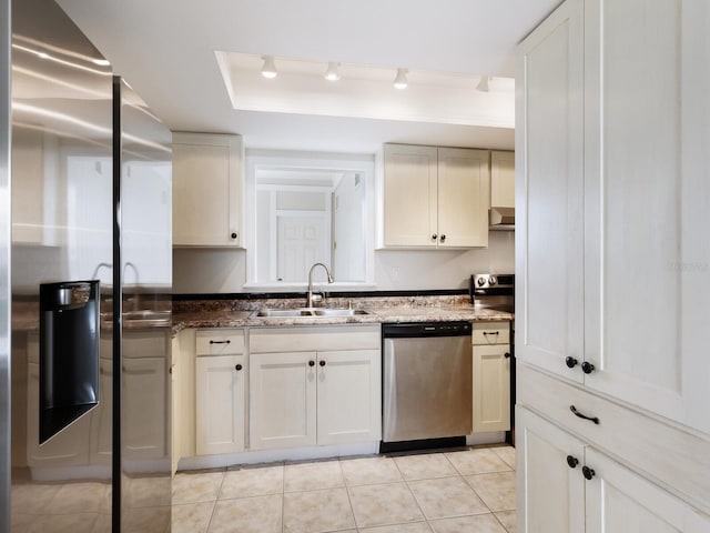 kitchen with light tile patterned floors, appliances with stainless steel finishes, sink, a raised ceiling, and rail lighting