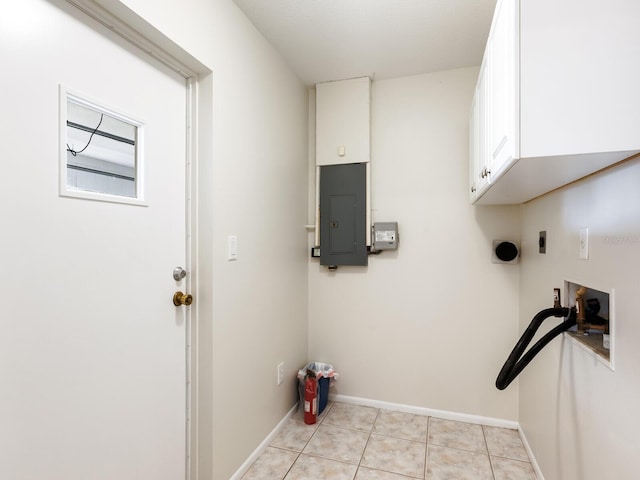 laundry area with cabinets, a wealth of natural light, electric dryer hookup, electric panel, and light tile patterned flooring