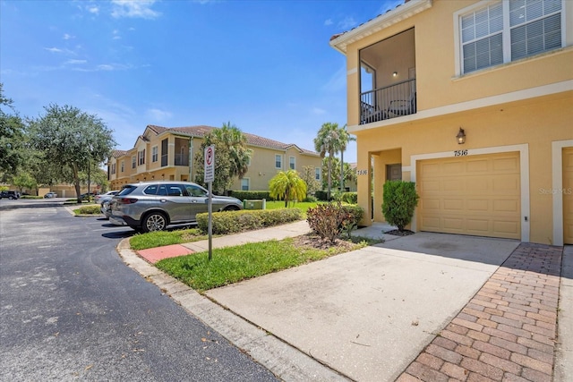 view of front of property featuring a balcony and a garage