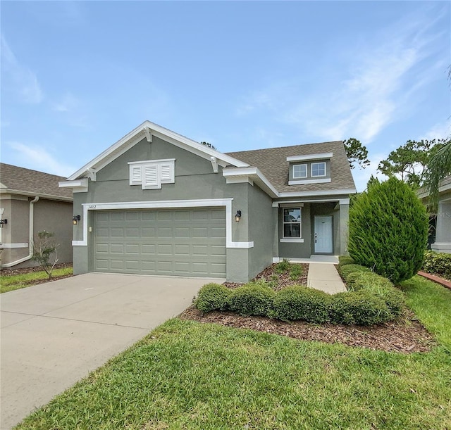 view of front of house featuring a garage, a front yard, concrete driveway, and stucco siding