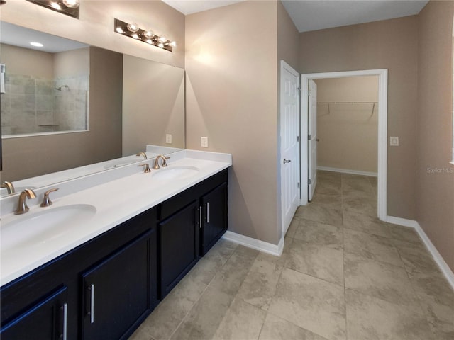 bathroom with double vanity, tile patterned floors, and a tile shower