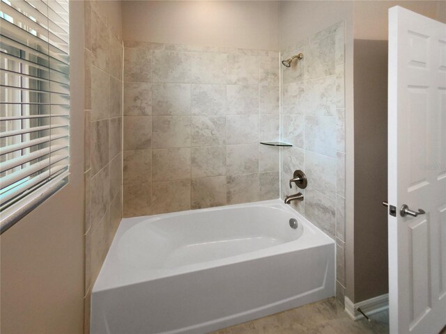 bathroom with tile patterned floors, tiled shower / bath, and a healthy amount of sunlight