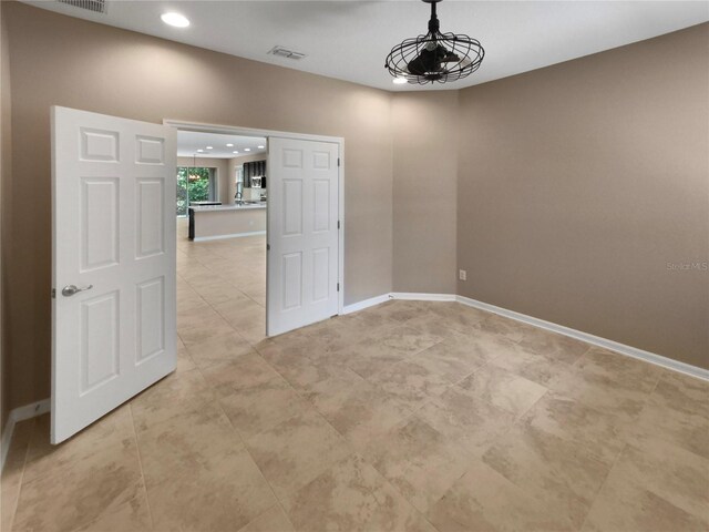 empty room with recessed lighting, visible vents, and baseboards