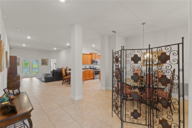 tiled dining space with vaulted ceiling, a chandelier, and french doors