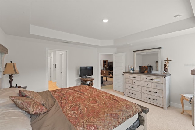 carpeted bedroom featuring a tray ceiling