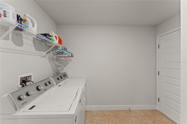 clothes washing area featuring separate washer and dryer and light tile patterned floors