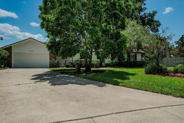 obstructed view of property with a front lawn and a garage