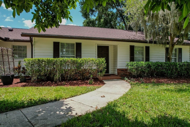 single story home featuring a front lawn