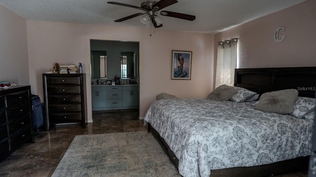 bedroom with a textured ceiling, ensuite bathroom, and ceiling fan