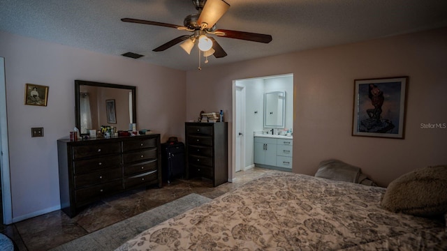 bedroom with ensuite bath, ceiling fan, and a textured ceiling