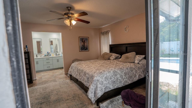 bedroom with multiple windows, ceiling fan, ensuite bathroom, and a textured ceiling