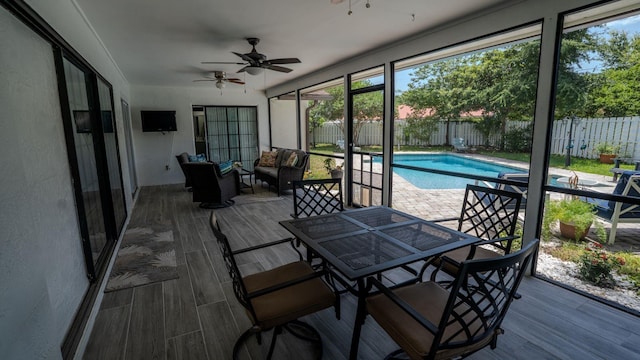 sunroom / solarium featuring ceiling fan