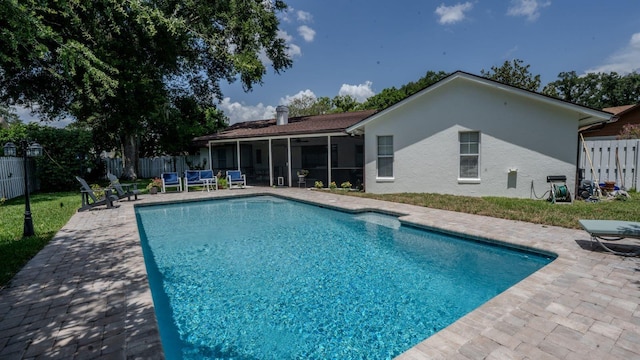 view of swimming pool featuring a patio area and a sunroom