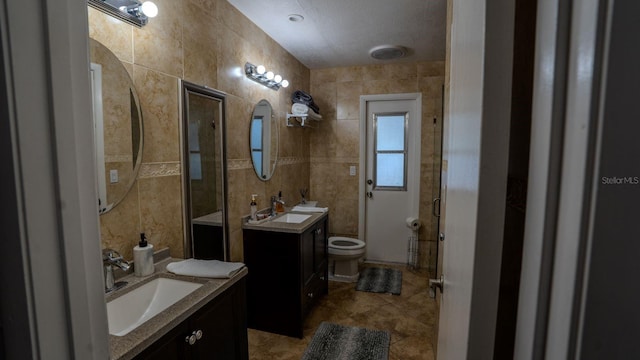 bathroom featuring tile patterned floors, an enclosed shower, vanity, tile walls, and toilet