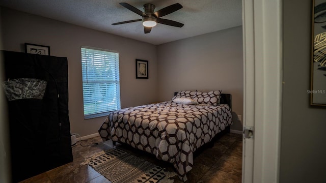 bedroom featuring ceiling fan and a textured ceiling