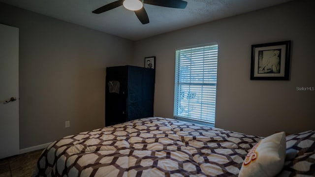 bedroom with ceiling fan and a textured ceiling