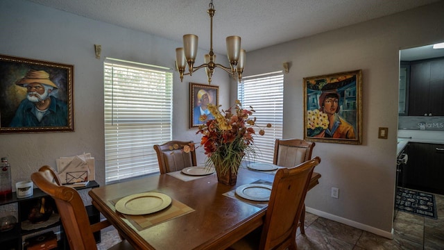 dining room featuring a healthy amount of sunlight, a textured ceiling, and an inviting chandelier