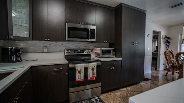 kitchen with stainless steel appliances, tasteful backsplash, and ornamental molding